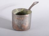 une petite tasse en métal contenant une cuillère
