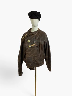 leather jacket on a mannequin stand with a hat on it