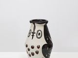 a black and white vase sitting on top of a white table