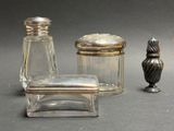 un petit récipient en verre avec un couvercle argenté, à côté d'un autre petit récipient en verre avec un couvercle argenté