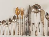 a lot of spoons and forks arranged on a wall