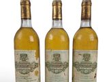 three bottles of wine sitting next to each other on a white surface