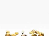 two pairs of gold and black stone stud earrings on a white background