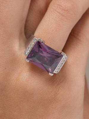 une image montrant un gros plan de la main d'une personne portant une bague sertie d'une pierre violette