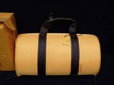 a yellow duffel bag sitting next to a yellow box