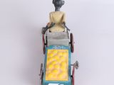 a figurine of a man in a cart with oranges on it