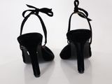 pair of black high heeled shoes on a white surface