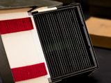a close up of a black and white box with a red stripe on it