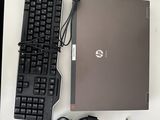 un ordinateur portable, un clavier, une souris et un tapis de souris posés sur un bureau
