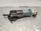 an electric drill is laying on a table in front of a sign