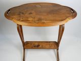 une table de forme ovale avec un plateau et des pieds en bois