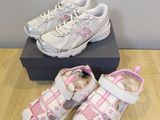 pair of toddler ' s white and pink shoes on a wooden floor