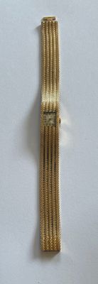 un bracelet en or orné d'une montre, posé sur un fond blanc