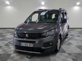 La camionnette grise est garée dans une grande pièce au sol carrelé.