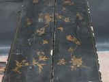 a small black table with gold flowers on it