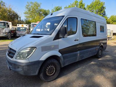 a silver van parked in a parking lot with other trucks