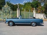 a blue convertible car parked in front of a gate