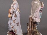 two figurines of a man and a woman standing next to each other