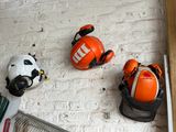 three helmets hanging on the wall next to a radiator
