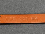 a close up of a brown leather keychain with a name engraved on it
