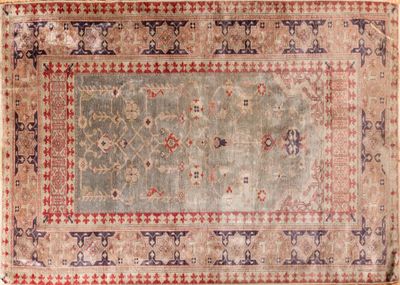 un tapis ancien orné d'une bordure bleue et rouge