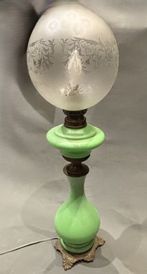 a green lamp with a glass globe on top of it