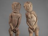 two wooden figures of a man and a woman standing next to each other