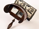 a small mirror with a wooden handle and a picture on it