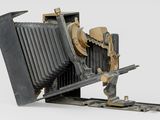photograph of an old camera on a white surface with a white background
