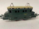 une image représentant un wagon de train miniature vert posé sur une surface blanche