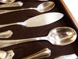plusieurs cuillères en argent et cuillères à soupe dans une boîte en bois