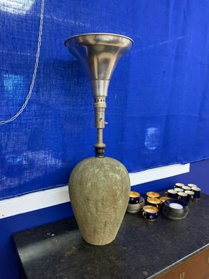 un vase orné d'une corne, posé sur une table devant un mur bleu
