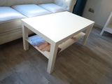 a white coffee table sitting in front of a white couch