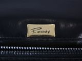 a close up of a black purse with a name tag on it