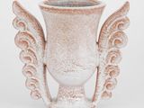 une image représentant un vase blanc orné d'ailes