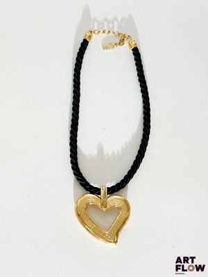 collier noir et doré avec un pendentif en forme de cœur doré sur un cordon noir
