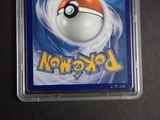 a pokemon card in a plastic case on a table