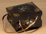 une petite boîte noire ornée d'un motif floral