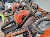 several chainsaws are lined up on a table in a warehouse