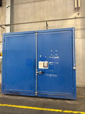 un grand conteneur bleu posé au milieu d'un parking