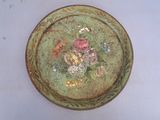 une assiette verte ornée de fleurs, posée sur un fond blanc
