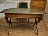une table en bois avec un plateau en verre vert, dans un coin de la pièce