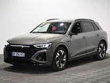 un SUV Audi gris garé dans une pièce au sol carrelé en damier