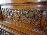 a close up of a wooden bed with carvings on the headboard