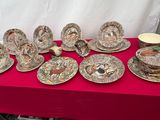 plusieurs assiettes et tasses sur une table avec une nappe rouge