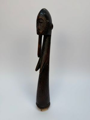 une figurine en bois représentant une femme portant une coiffe