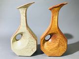 deux vases posés l'un à côté de l'autre sur une table