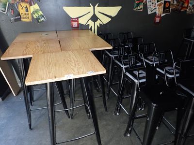 des tables et des chaises dans une pièce où sont accrochées des affiches au mur