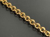 a close up of a gold chain on a black surface