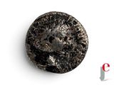 a close up of a coin with a face on it